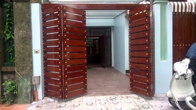 Một cổng gỗ cổ điển với 4 cánh mở ra để sử dụng cho mục đích dân dụng.