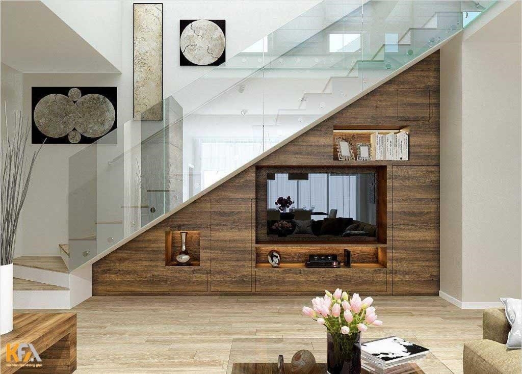 Phía dưới cầu thang, tấm vách tivi trong phòng khách được làm từ gỗ tự nhiên vô cùng đẳng cấp và sang trọng.